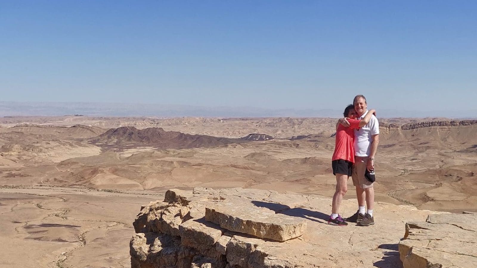 A couple embracing at the rim of Makhtesh Ramon, overlooking the Negev crater