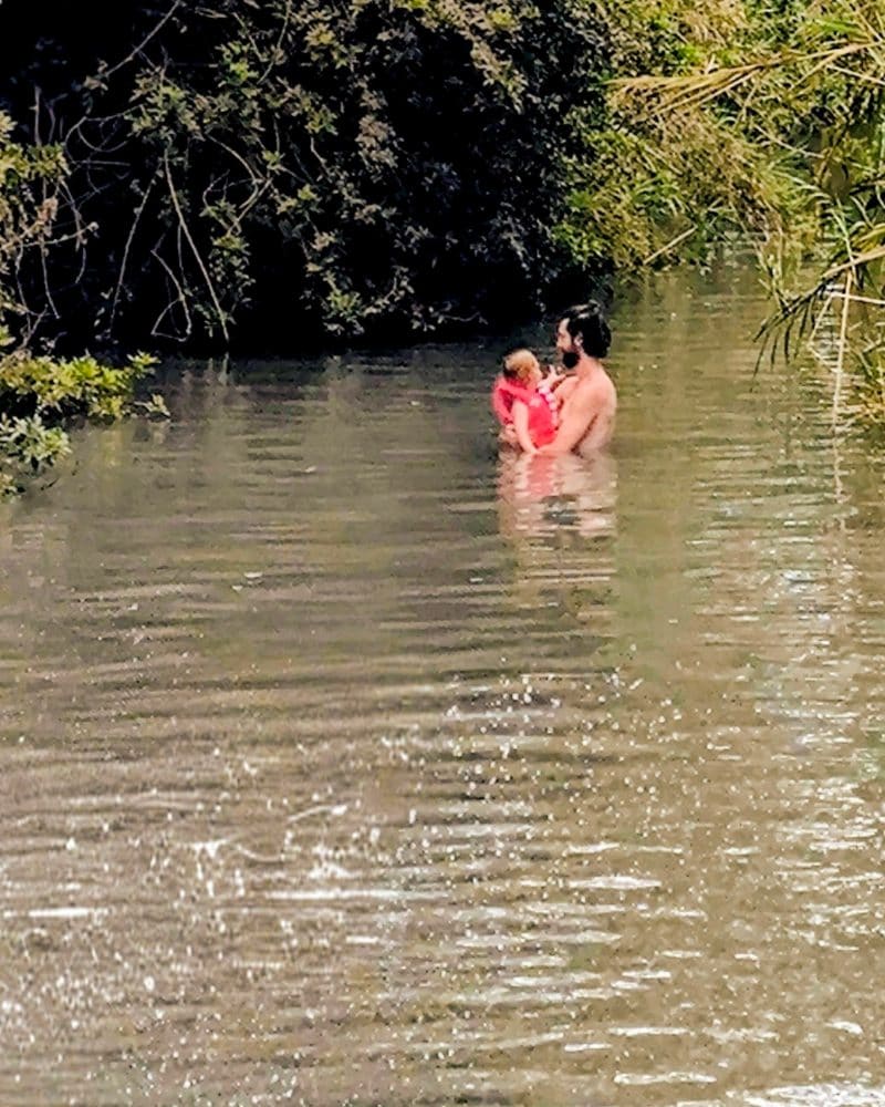 Ari with his family, wading in a river in Israel