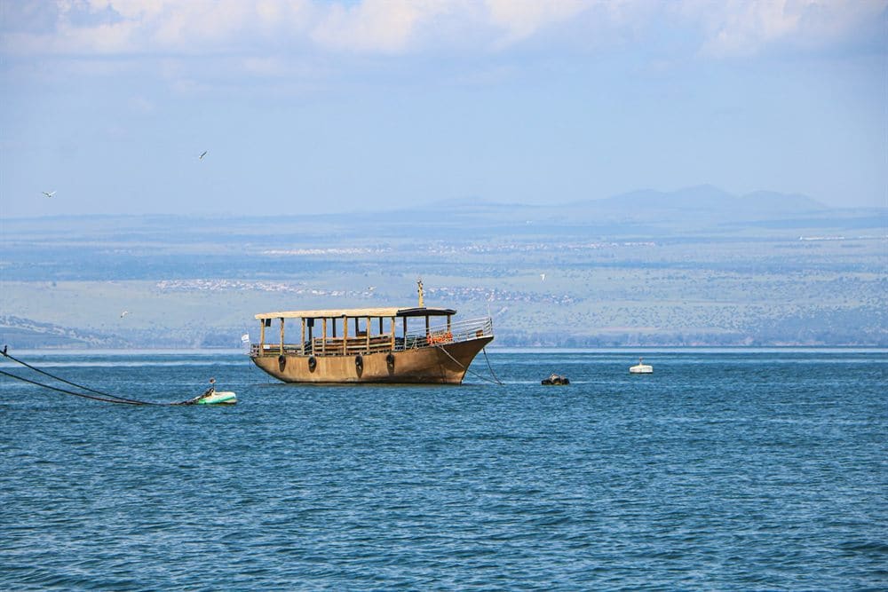 Wooden boat floating on the calm Sea of Galilee near Tiberias