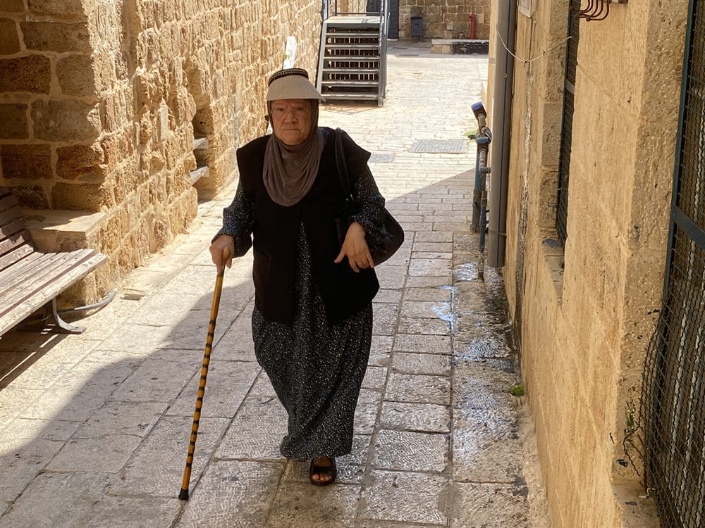A woman walking through the stone streets of Acre's Old City