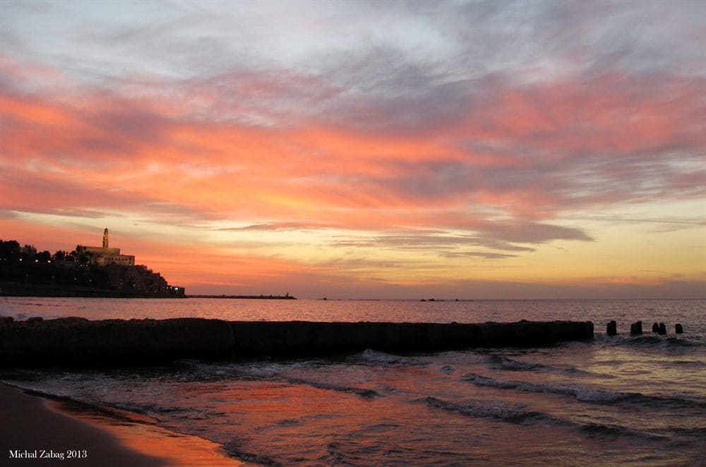 Old Jaffa silhouetted against a deep red sunset